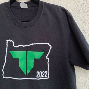 Portland Timbers 2022 black Tee shirt with white and green graphic.